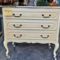 Vintage cremekleurige kast met donkerblauwe lades en sierlij – kavel bij BOPA Auctions, Aarsele